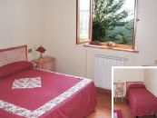 Camera luminosa in agriturismo, arredamento semplice e funzionale, ideale per un soggiorno tranquillo in Umbria.