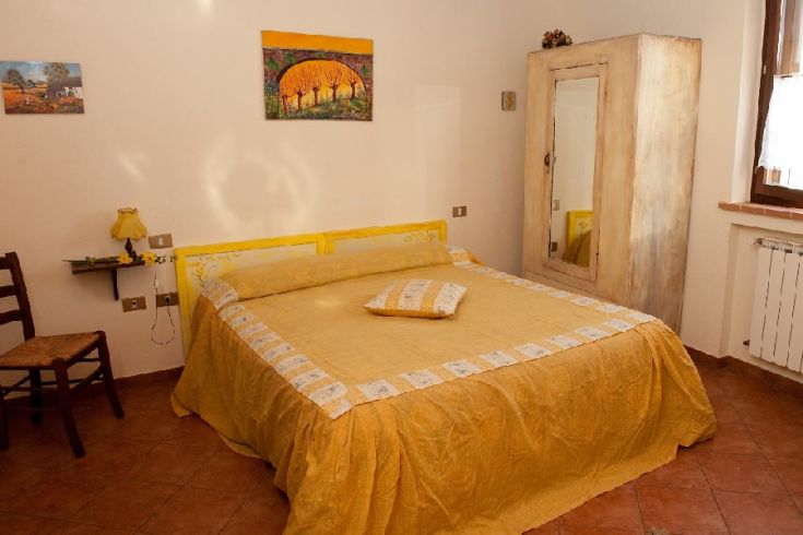 Camera matrimoniale luminosa e accogliente, con arredamento caldo e panorami rilassanti sulla natura circostante.