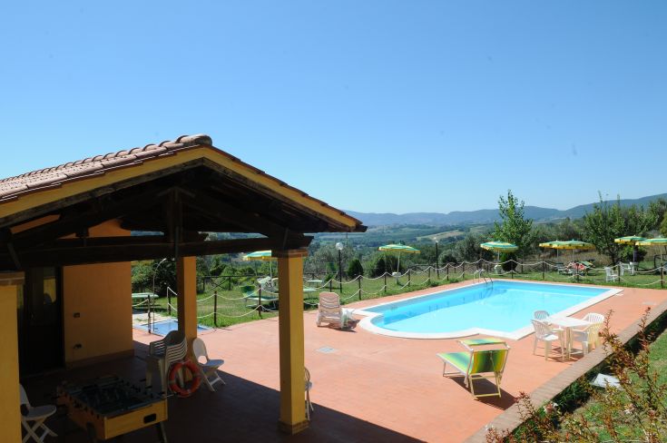 Agriturismo circondato da colline umbre, con piscina e spazi ideali per momenti di relax e una bella vista sulla natura.