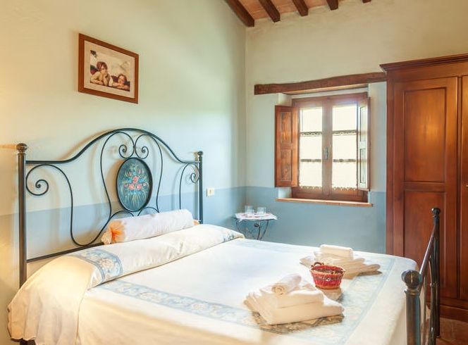 Gemütliches Zimmer mit Schmiedeeisenbetten und Holzmöbeln, perfekt zum Entspannen.