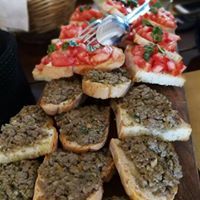 Bruschetta mit frischen Tomaten und einer leichten Schicht Pâté, serviert auf goldenen Crostini.