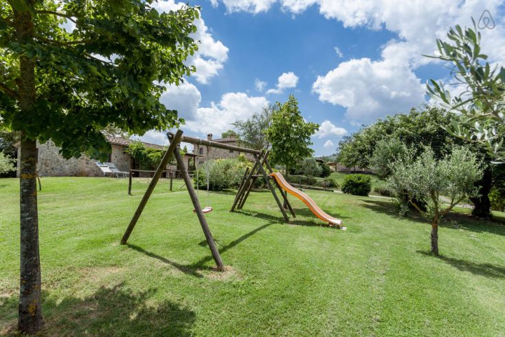 Aktivitäten im Freien für Kinder auf einem Bauernhof, umgeben von Grün und unter einem klaren Himmel.