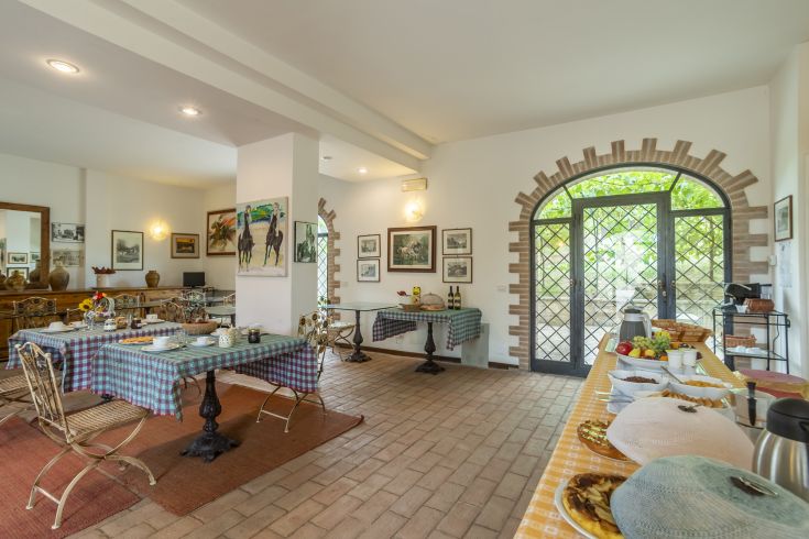 Ein einfacher Speisesaal mit Tischen und Stühlen, bereit, Gäste mit traditionellen Gerichten zu empfangen.