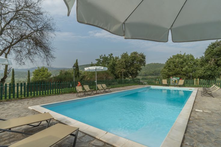 Ein Außenpool, umgeben von Hügeln und Bäumen, der einen ruhigen Ort zum Entspannen bietet.