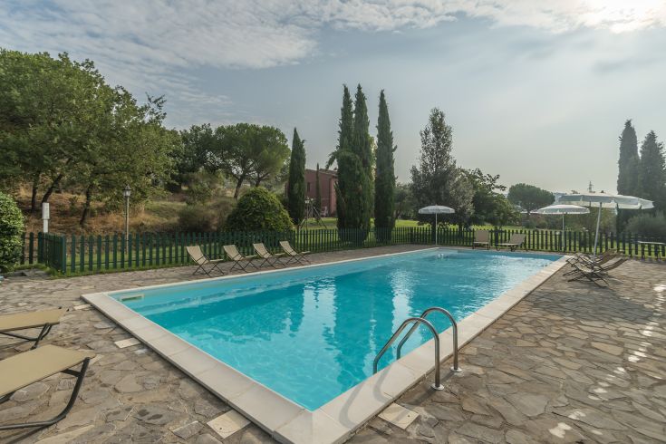 Ein natürlicher Pool in einer ruhigen Umgebung, umgeben von Bäumen und Pflanzen.