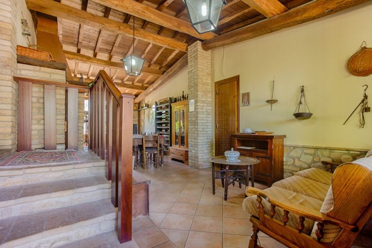 Un interno di un agriturismo, caratterizzato da travi a vista in legno e mobili in stile rustico.