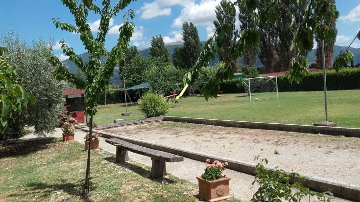 Un'area verde con giochi per bambini e un campo da calcio, ideale per momenti di svago e relax in campagna.