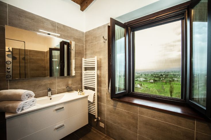A simple and functional bathroom overlooking the surrounding hills, furnished for practicality.