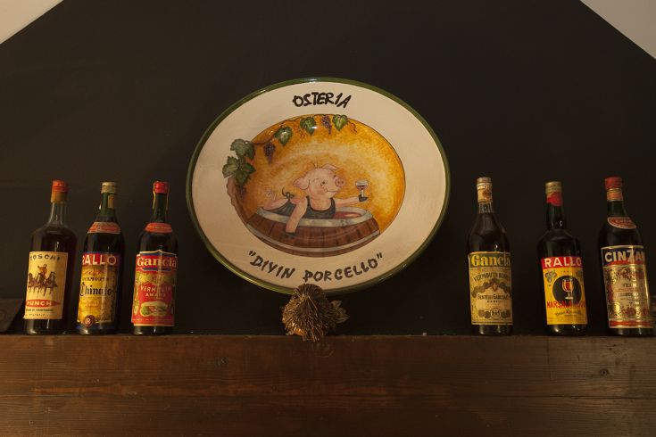 A traditional tavern with simple furnishings and a display of spirits in the showcase.