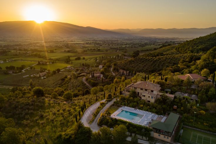 View of Poggio degli Olivi surrounded by the Umbrian nature, with the sunset on the horizon.