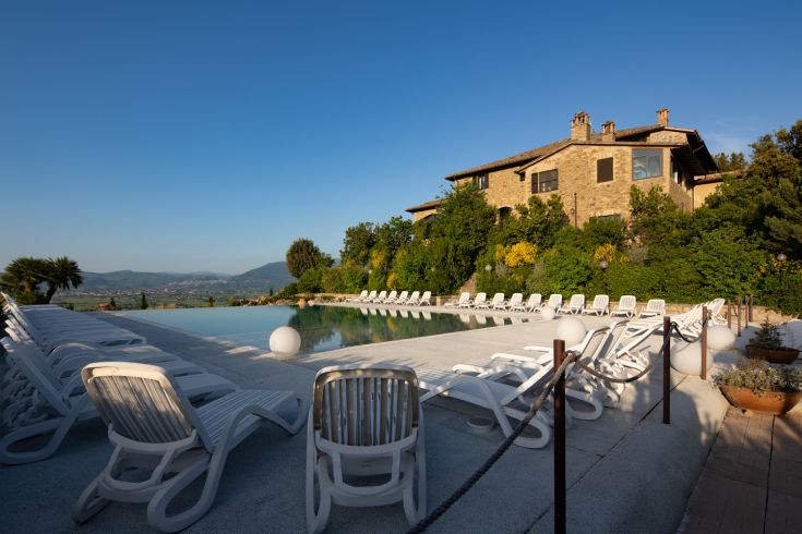 A relais surrounded by nature, featuring a pool and views of Assisi, perfect for relaxing moments.