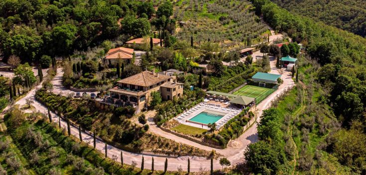 Poggio degli Olivi is a serene agriturismo in a rural area, surrounded by trees and fields.