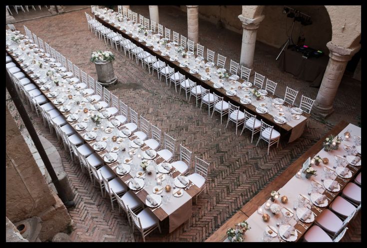 Eine einfache Tischdekoration mit Tischdecken, Blumen und Kerzen für eine Veranstaltung.