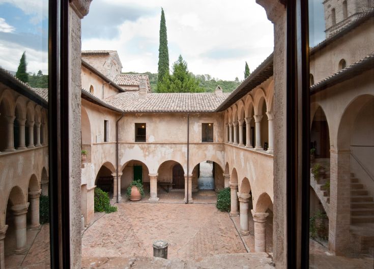 Szene des Klosters der Abtei, umgeben von Bäumen und mit eleganten, schlichten Bögen.