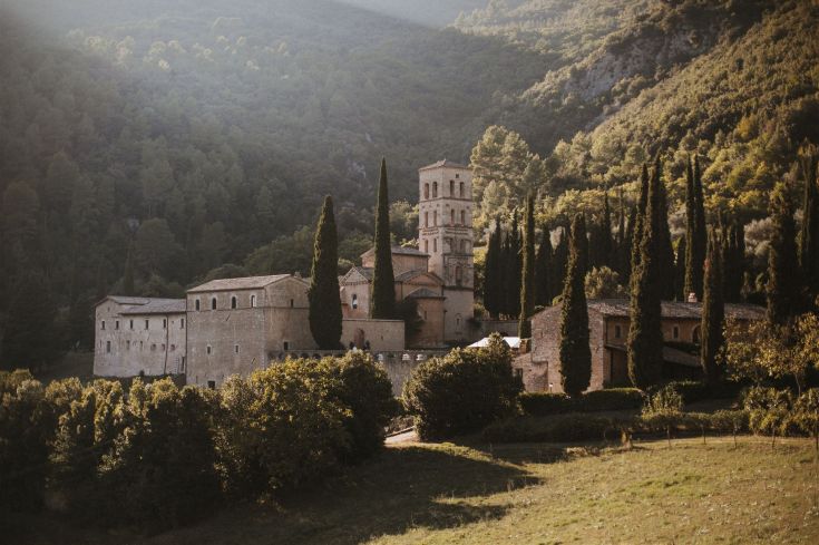 Die Abtei San Pietro in Valle liegt in einem Wald und bietet einen atemberaubenden Blick auf das umliegende Tal.