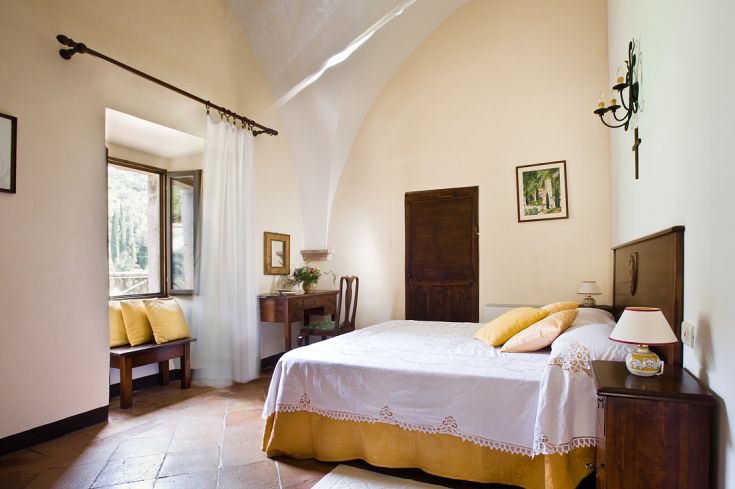 Einfache Zimmer der Abtei San Pietro in Valle, mit Blick auf die umliegenden Hügel. Ideal für einen ruhigen Aufenthalt.