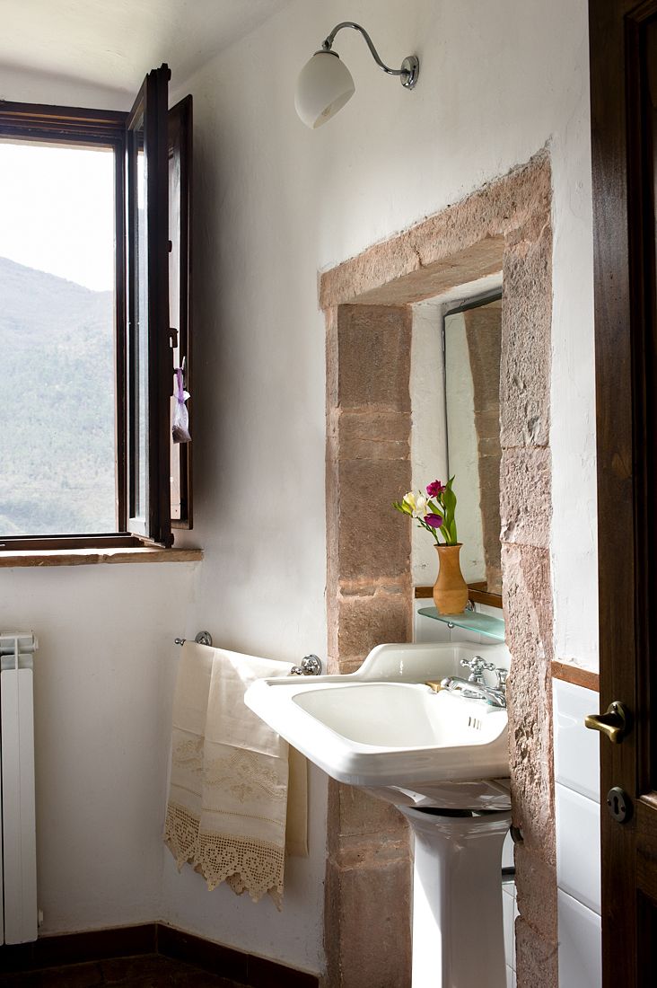 Ein einfaches Badezimmer mit natürlichem Licht und rustikalen Details.