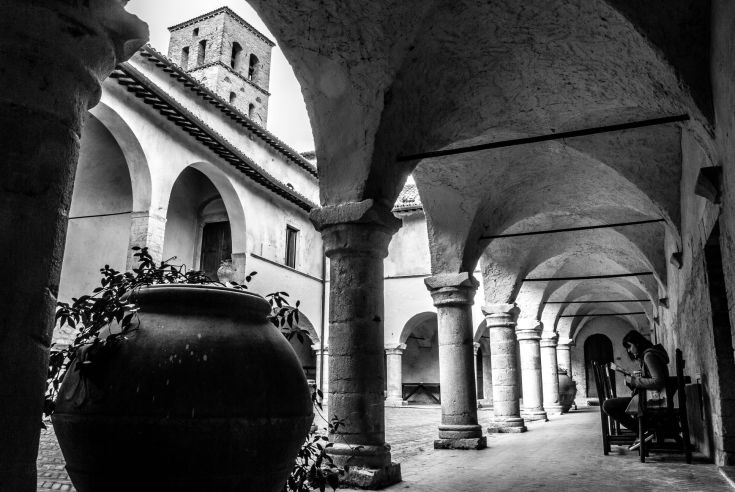 Blick auf das Kloster mit eleganten Bögen und üppigem Grün, das eine ruhige Atmosphäre schafft.