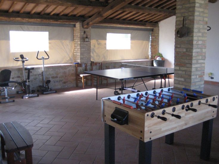 A play area equipped with a ping pong table and a foosball table, perfect for fun and relaxation.