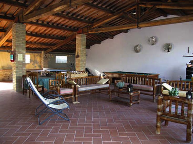 A spacious and bright environment with exposed wooden beams and simple decor, suitable for social gatherings.