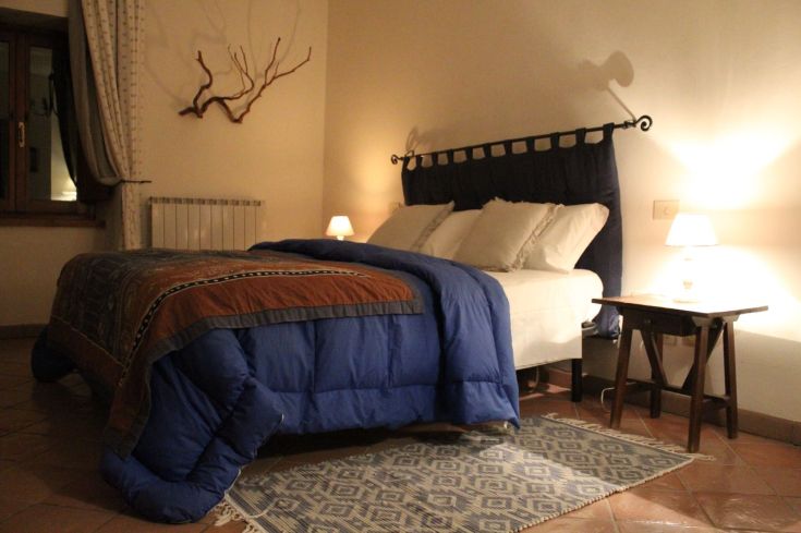 Simple bedroom with a double bed and warm-toned furnishings, perfect for relaxation moments.