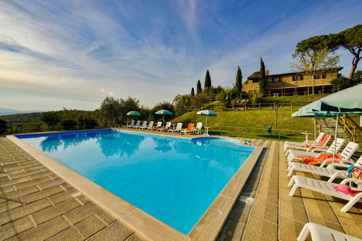 Agriturismo con piscina circondata dalla natura umbra, perfetto per trascorrere una vacanza tranquilla.