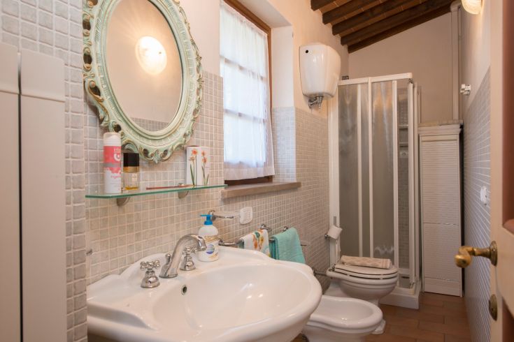 Un bagno semplice e religioso con doccia e lavandino, ideale per momenti di relax.