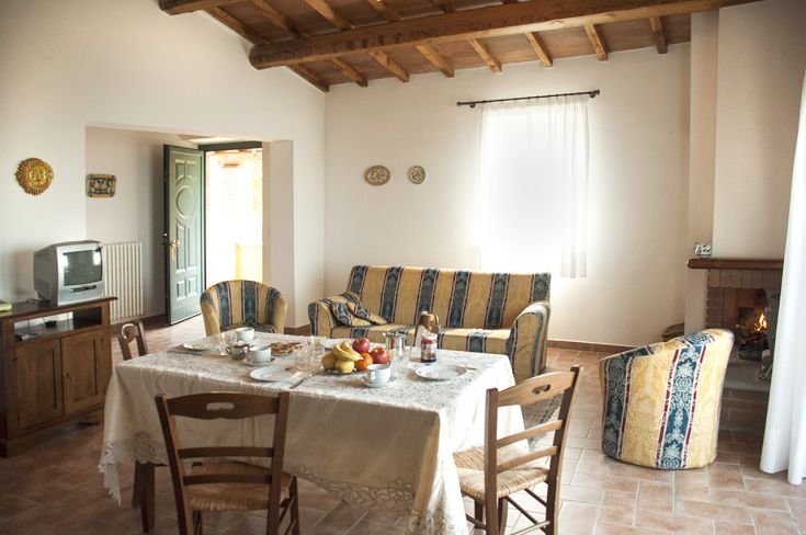 Un soggiorno confortevole, arredato con dettagli rustici e affacciato su un bello spazio verde.