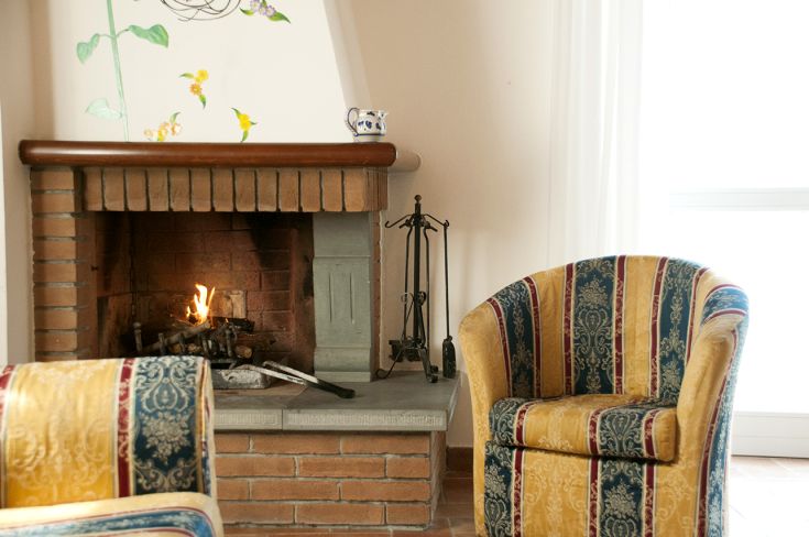 Un soggiorno semplice con camino e poltrone, ideale per momenti di tranquillità.