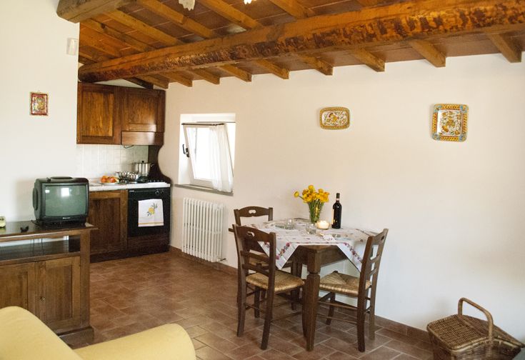 Soggiorno spazioso con cucina, arredato in stile semplice e funzionale, ideale per una vacanza tranquilla in Umbria.