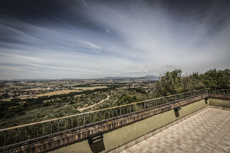 Panorama sulle colline umbre con Torgiano in lontananza, immerso nella natura circostante.