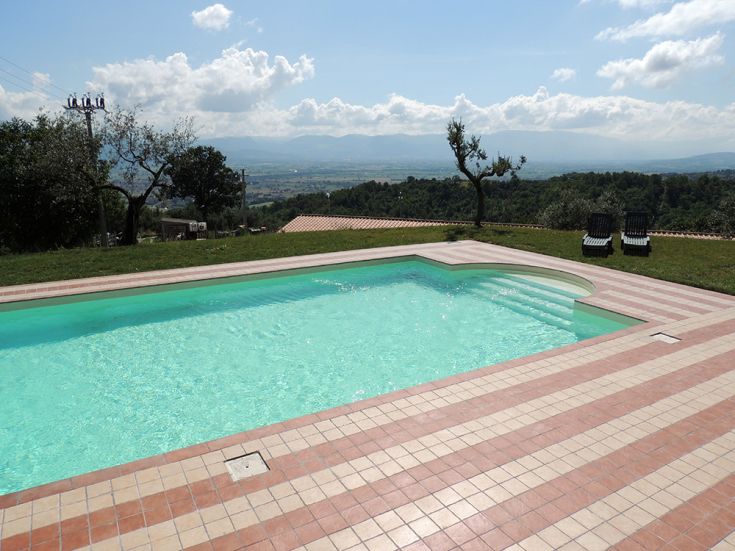 Una piscina situata nella natura umbra, con panorama su un contesto collinare.