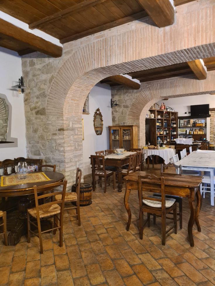 Spazio semplice e accogliente di un agriturismo con mobili in legno e pavimentazione in piastrelle.