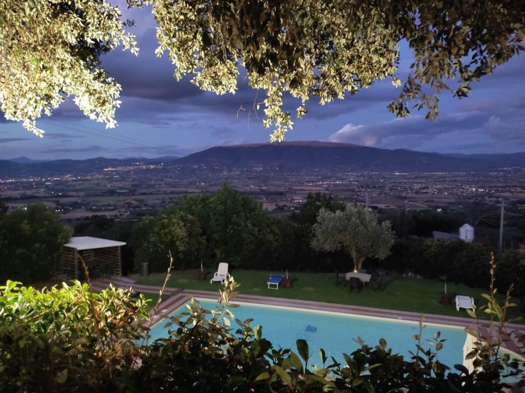 Scena serale su Assisi con la Valle Umbra sullo sfondo, immersi nella natura.