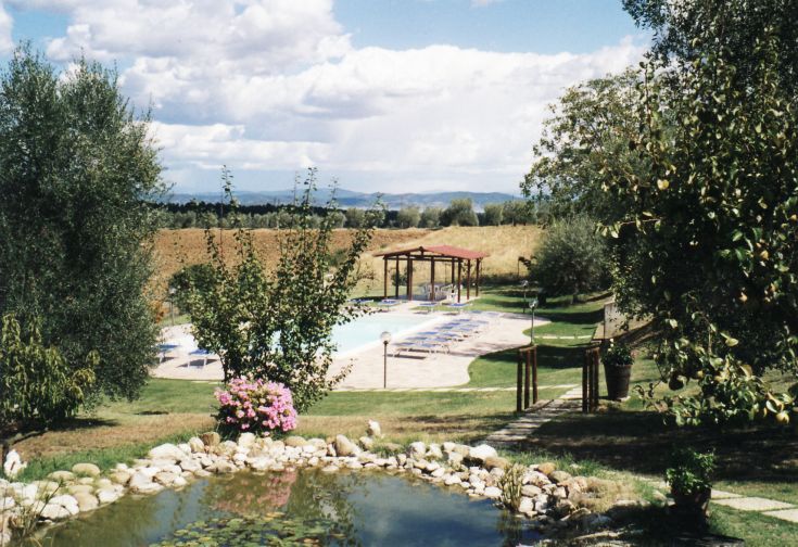 Panorama des Agriturismo-Parks mit Pool und gepflegtem Garten. Ein ruhiger Ort, umgeben von Natur.