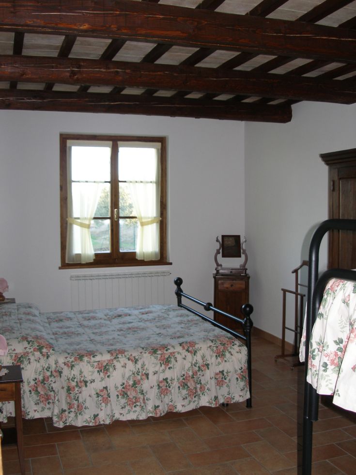 Gemütliches Zimmer mit einem Doppelbett und dekorativen Blumendetails. Perfekt für Momente der Ruhe.