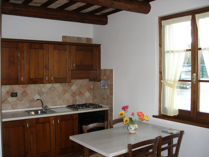 Gemütliche Küche mit einfacher Gestaltung und einem Tisch, der mit frischen Blumen geschmückt ist, perfekt für gemeinsame Mahlzeiten.