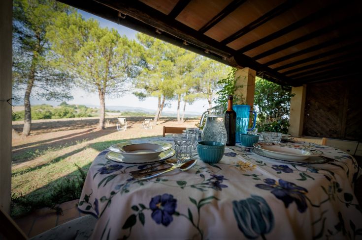 A table set up for an outdoor meal, surrounded by nature with trees on the sides.