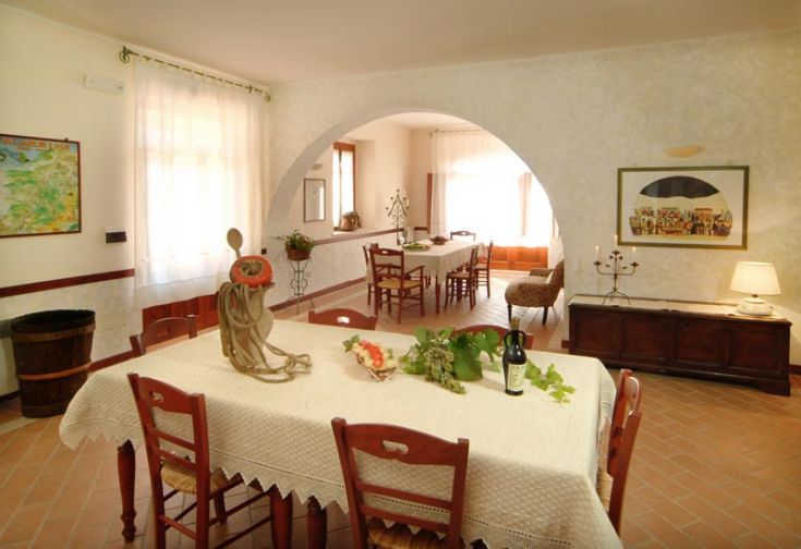 Un agriturismo in Umbria con un ambiente semplice, tavolo in legno e decorazioni naturali intorno.