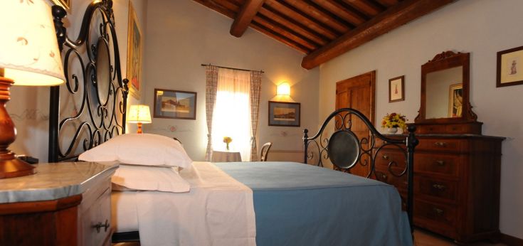 Camera confortevole in una storica struttura dell'Umbria, caratterizzata da mobili semplici e dotata di comfort attuali.