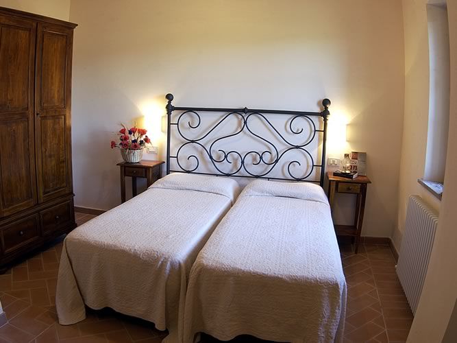 Simple space with single beds, wooden wardrobe, and a cozy atmosphere.