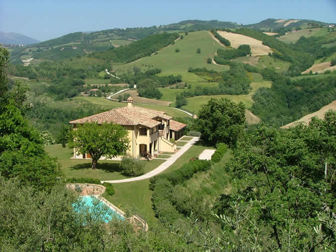 Un'azienda agrituristica circondata da colline verdi, dotata di piscina e di un bel panorama sul paesaggio circostante.