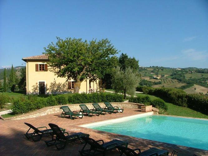 Building with a pool nestled in greenery, surrounded by olive groves and forests in the Umbrian countryside, ideal for a peaceful stay.