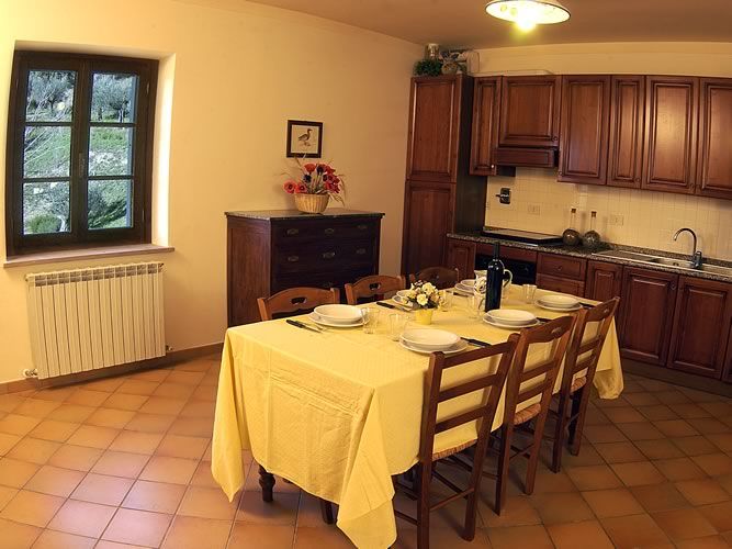 A simple interior of a rustic kitchen with a dining table set for meals.
