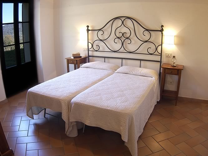 Bright and cozy room with twin beds and simple furnishings.