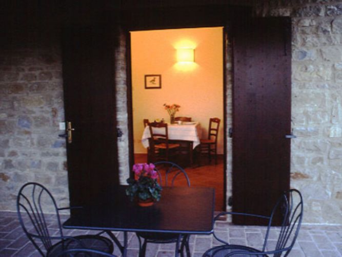 A simple entrance with an outdoor table, surrounded by a calm and natural atmosphere.