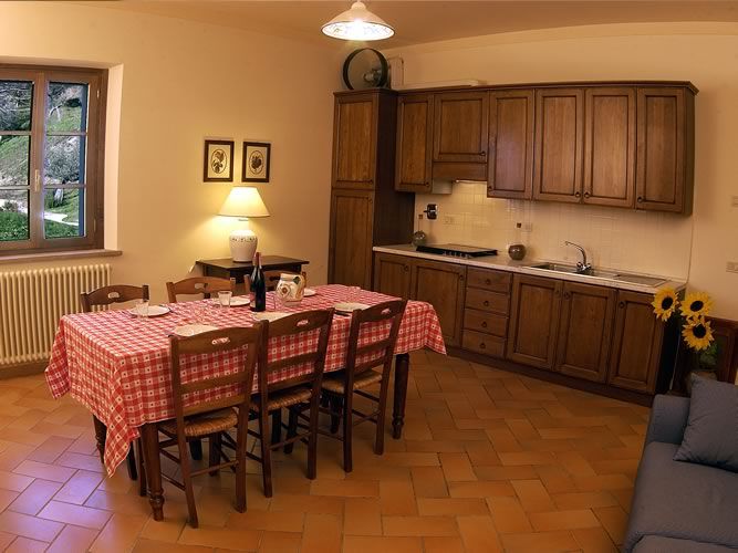 Spacious and cozy kitchen with a wooden dining table and decorative wood elements, ideal for shared meals.