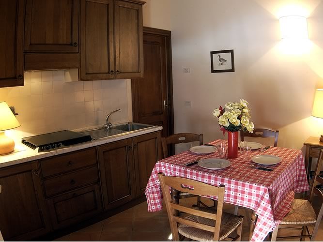 Simple kitchen with a round table and fresh flowers, perfect for gathering with family and friends.
