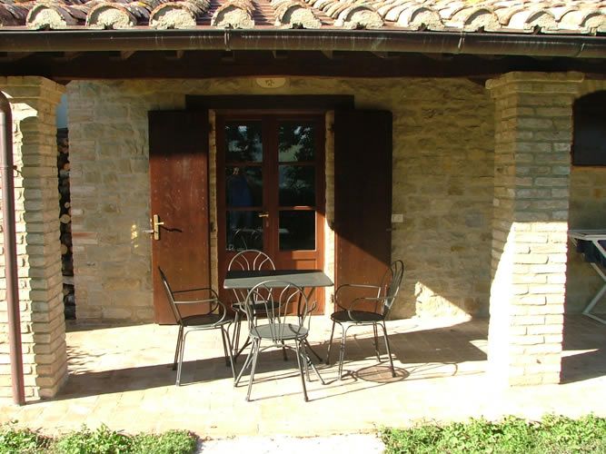 A simple terrace overlooking a green area, perfect for relaxing outdoors.