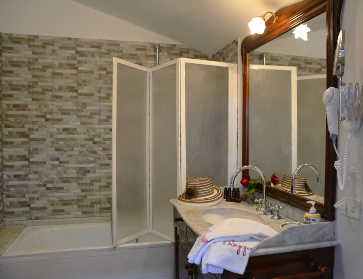 Ein einfaches Badezimmer mit Marmorfliesen und einem Marmorlwaschbecken. Eine ruhige Atmosphäre mit einfachen Details.